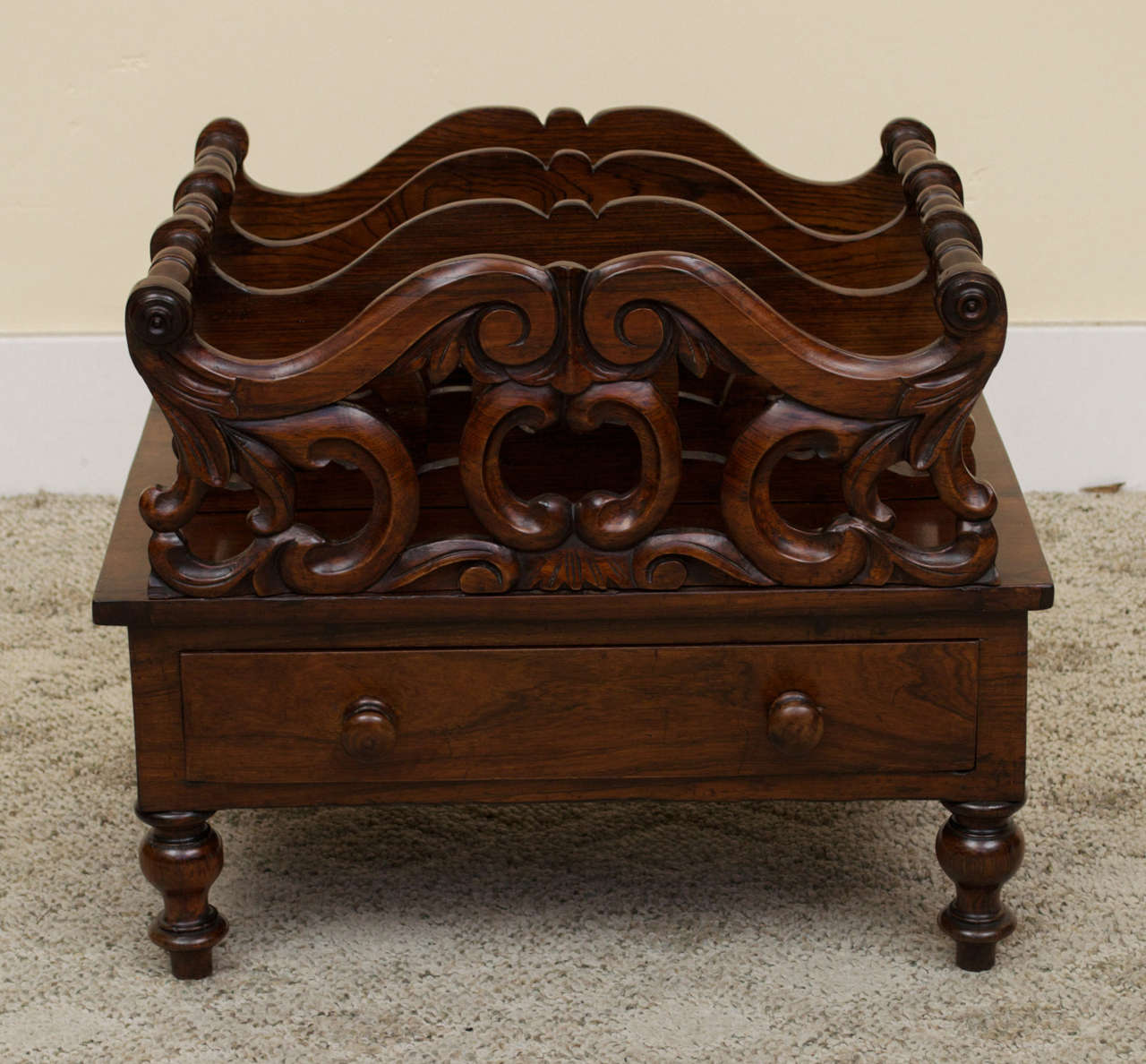 A beautiful carved Victorian mahogany Canterbury fitted with a single drawer. There are four shaped fretwork dividers with the front one having decorative carvings. A Canterbury was originally used to hold sheet music or dishes and now they are used