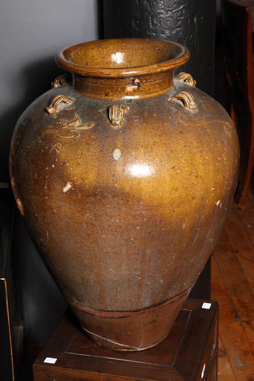 A Chinese Yuan dynasty 12th-13th century Martaban jar with ochre glaze. This ochre glazed jar comes from the Chinese Yuan dynasty (1279-1368) Martaban kilns. The jar showcases the typical Martaban shape, with a tapered unglazed foot and a large