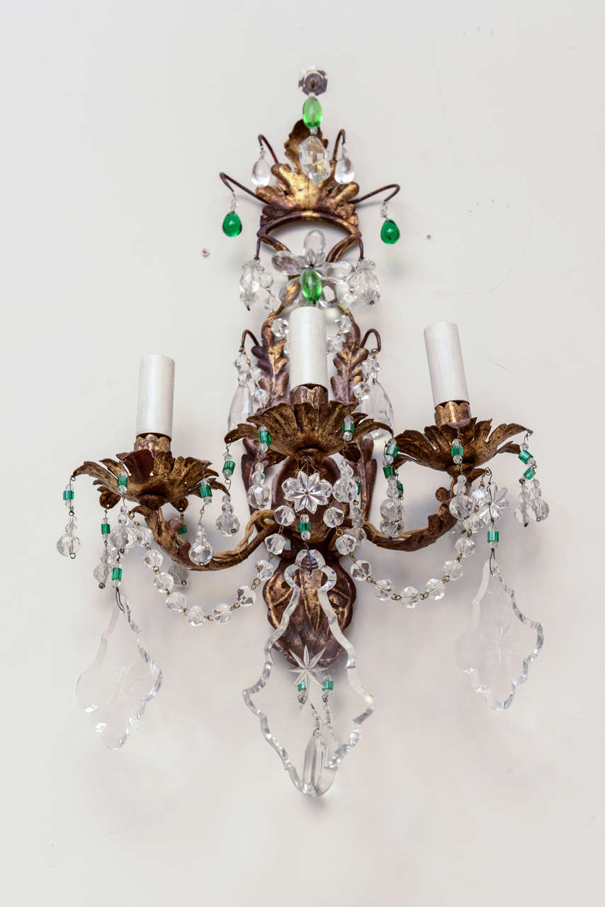 Pair of sconces, of gilded iron, draped with crystals, including some green accents, each having three scrolling candlearms.  Electrified.

Stock ID: D6612