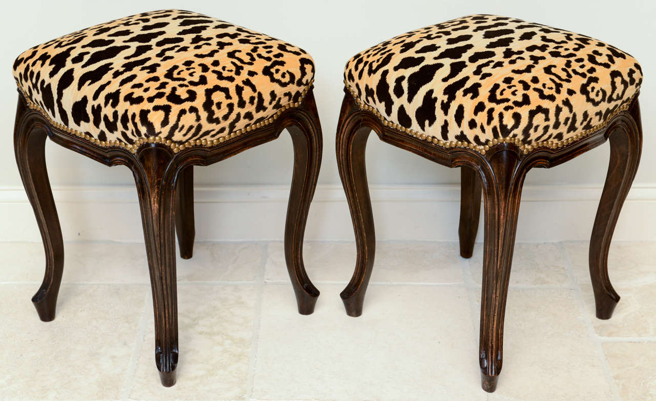 Pair of stools, of walnut; each having a square crown seat of leopard-print velvet (swatch available) with nailheads, on a channeled frame, raised on cabriole legs with scroll toes.

Stock ID: D4009
