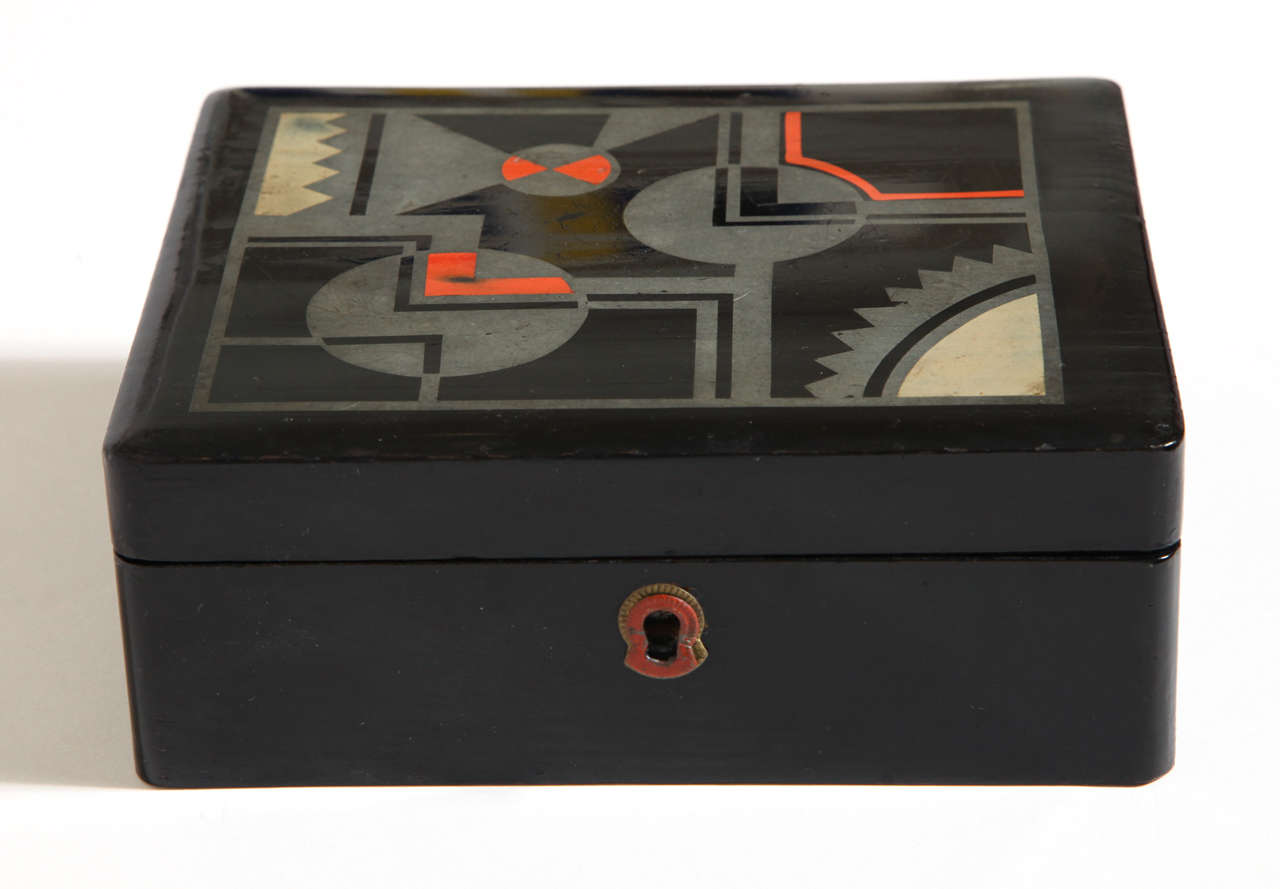 Black lacquered box with geometric design on top in gray, black, red and beige lacquer.
Hinged with lock, no key.

(Price shown is reduced price, no further trade discount) 