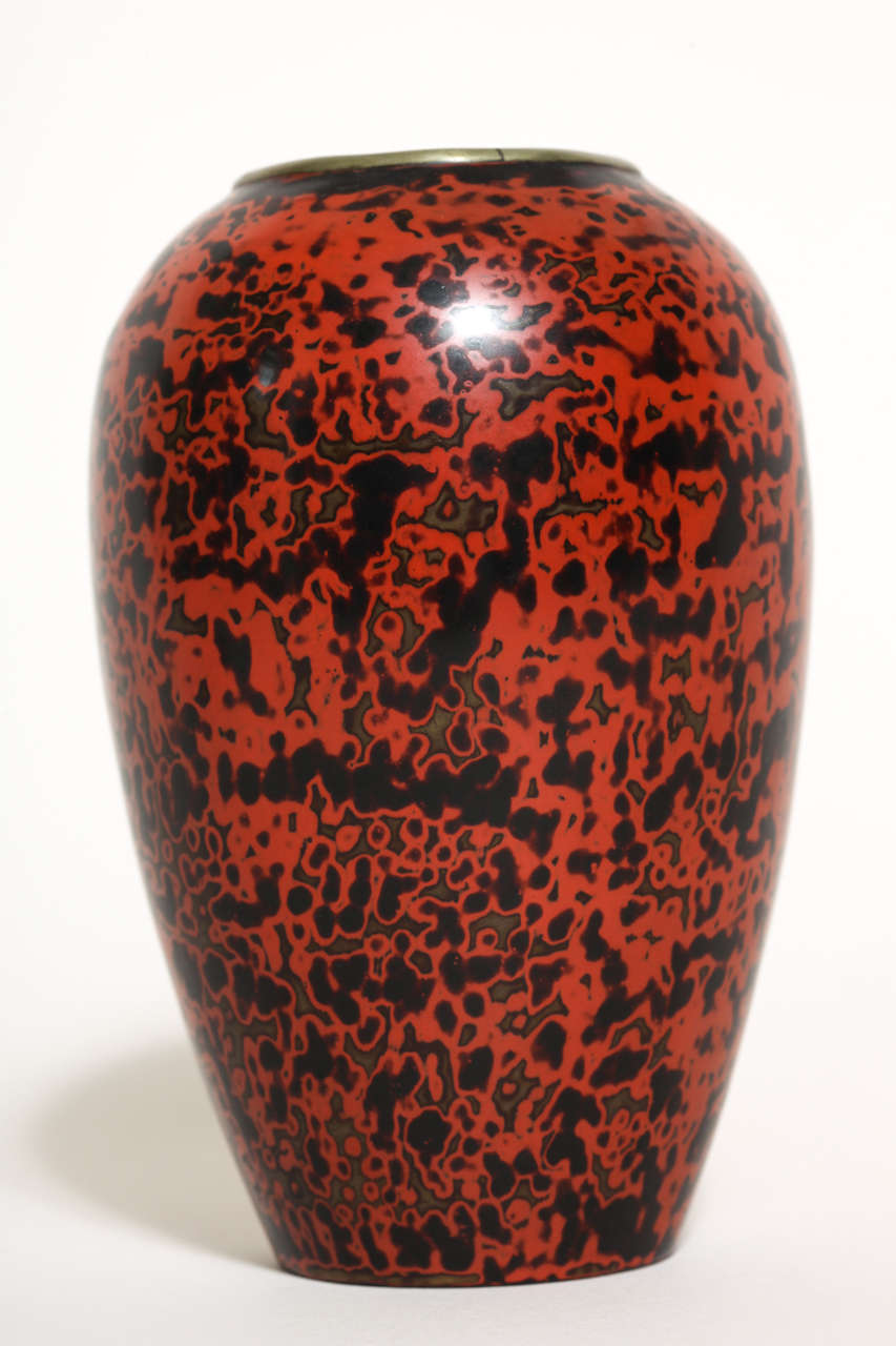 This is a beautiful brass vase with black tortoiseshell pattern on red lacquer ground 
Signed in red lacquer JEAN DUNAND

In 1912, Dunand learned the ancient and traditional art of Oriental lacquer work from the Japanese master lacquer artist Seizo