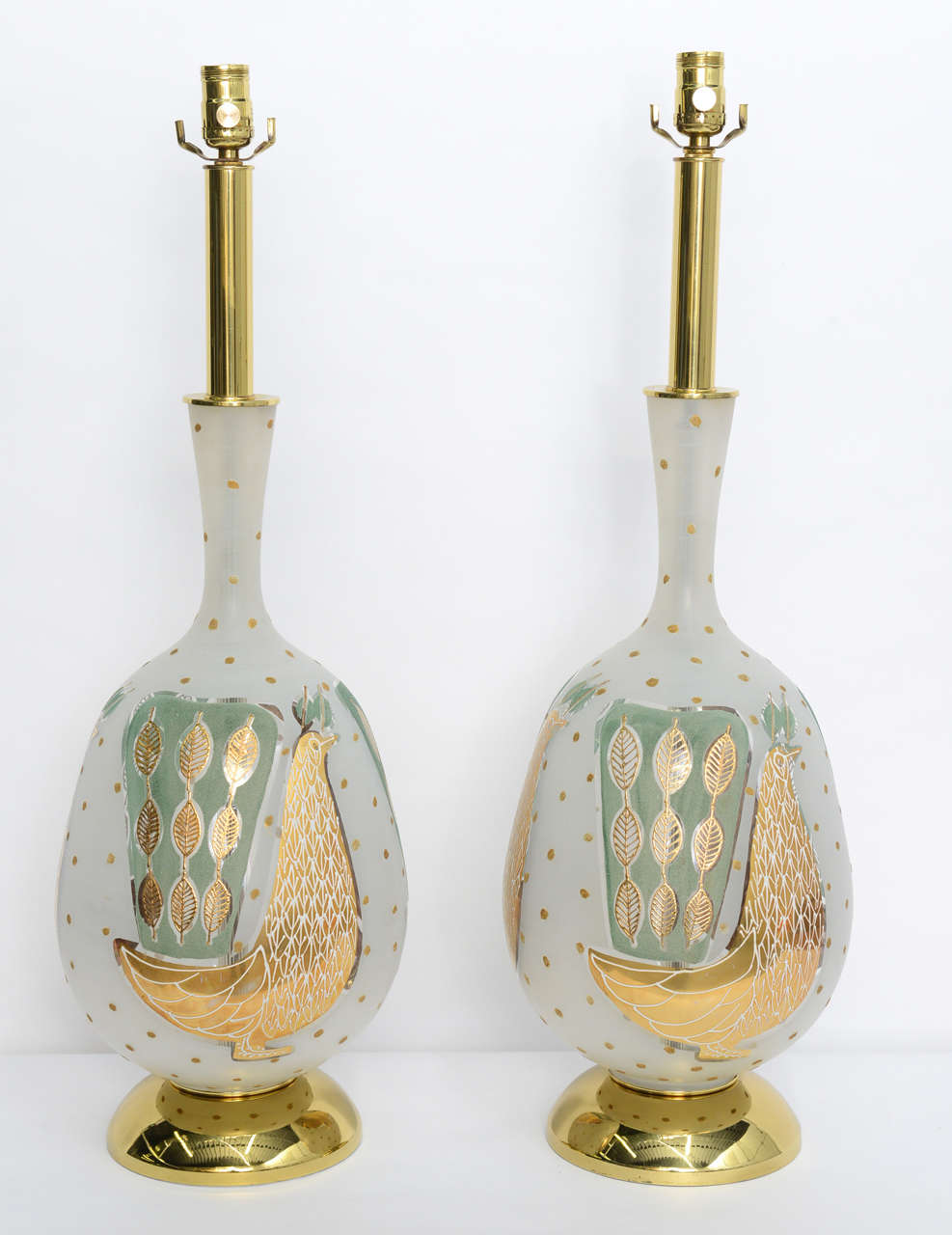 ...SOLD...Beautifully applied teal and gilt peacocks highlight this pair of Waylande Gregory style table lamps.  Standing on bright polished brass socle bases, the Italian bulbous frosted blown glass vase forms are topped with brass stems to the