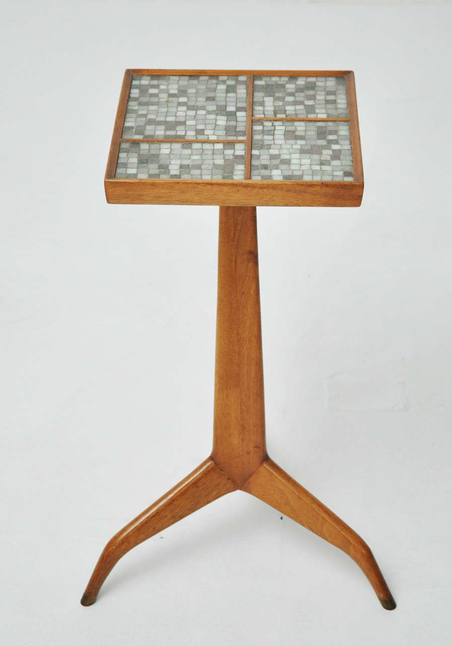 Tripod table designed by Edward Wormley for Dunbar. Murano glass tiles inset on top. Bras tips at feet.

Top measures: 10