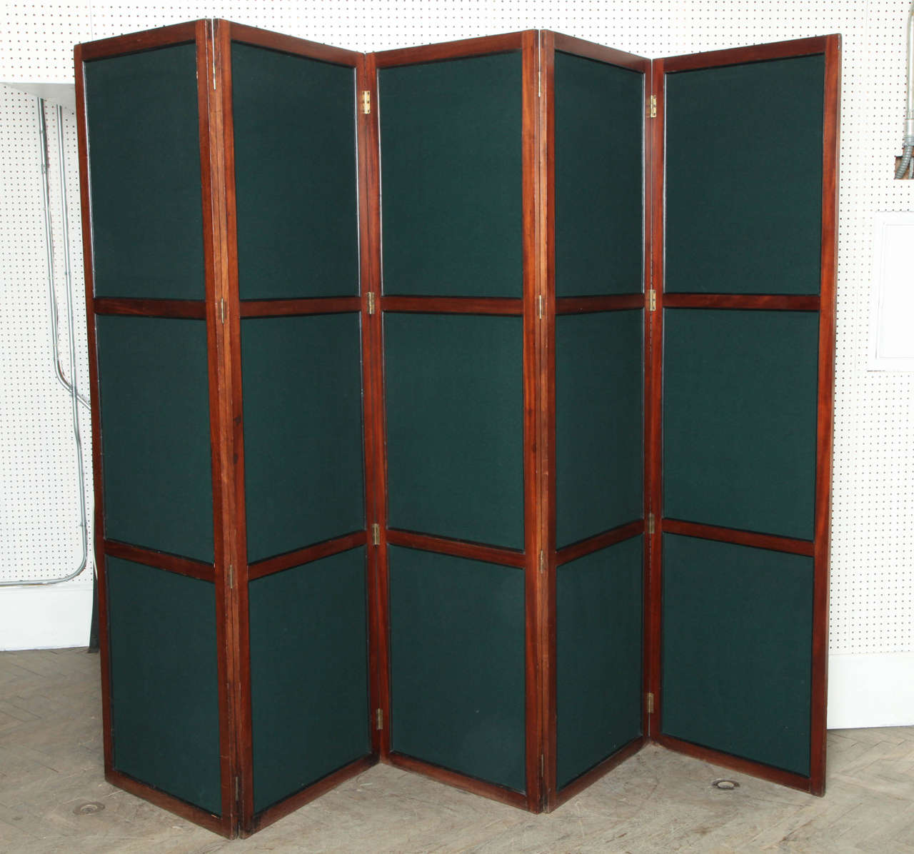 This is an antique screen or divider made of mahogany and inset with fabric. These screens were historically used to block off or hide areas of the room with servers or dining prep during the victorian era. 

MEASUREMENTS PER PANEL