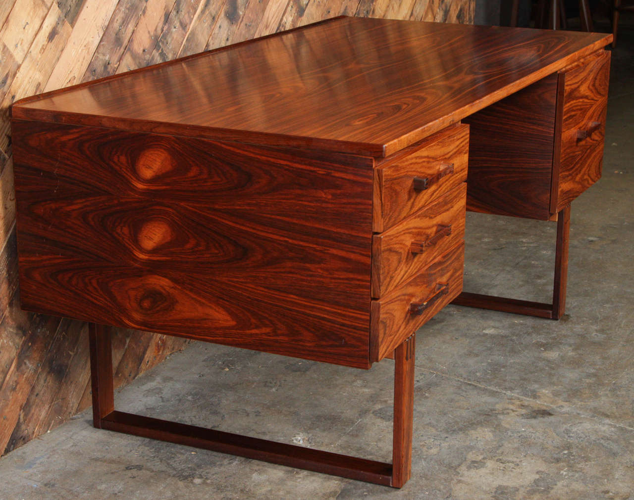 Rare desk by Torben Valeur and Henning Jensen for Schou Andersen. In rosewood with magnificent graining and the exposed, finger joint construction. Original, but excellent condition. Details include, a subtle raised lip along the back edge, exposed