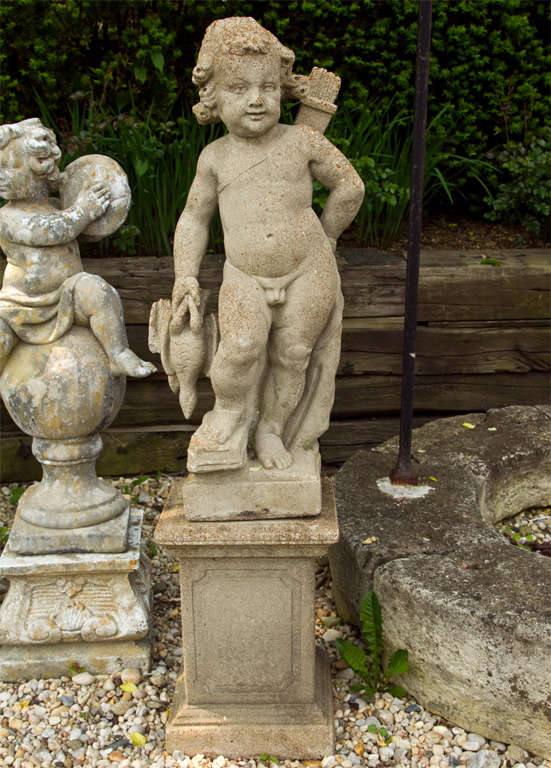 Pair of cast stone allegorical figures in the form of putti.<br />
One with wheat symbolizing abundance a one featuring the hunt motif, on pedestals (19'H x 14