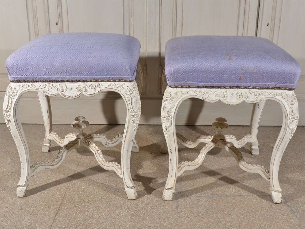 Chalk white decoratively carved stools from the estate of Herbert Wells, premier designer of Houston.  Upholstered by Wells Design.  Comfortable size.