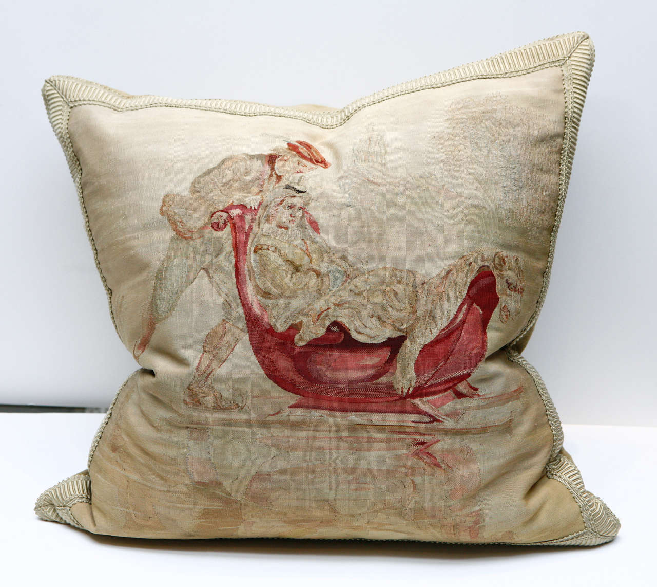 Large Aubusson pillow with a scene showing a reclining woman covered with an animal skin throw in a sled being pushed by man.