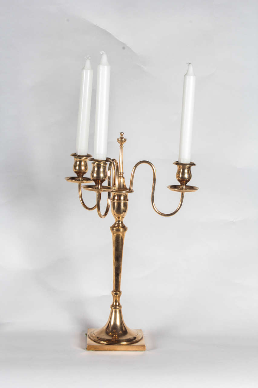 A pair of Swedish brass candelabra from Skultuna, Circa 1860s, each with three scrolled arms set into a removable center bobeche, on a circular spreading stem ending with a square base. Can be used as candlesticks.

Stamped on Base