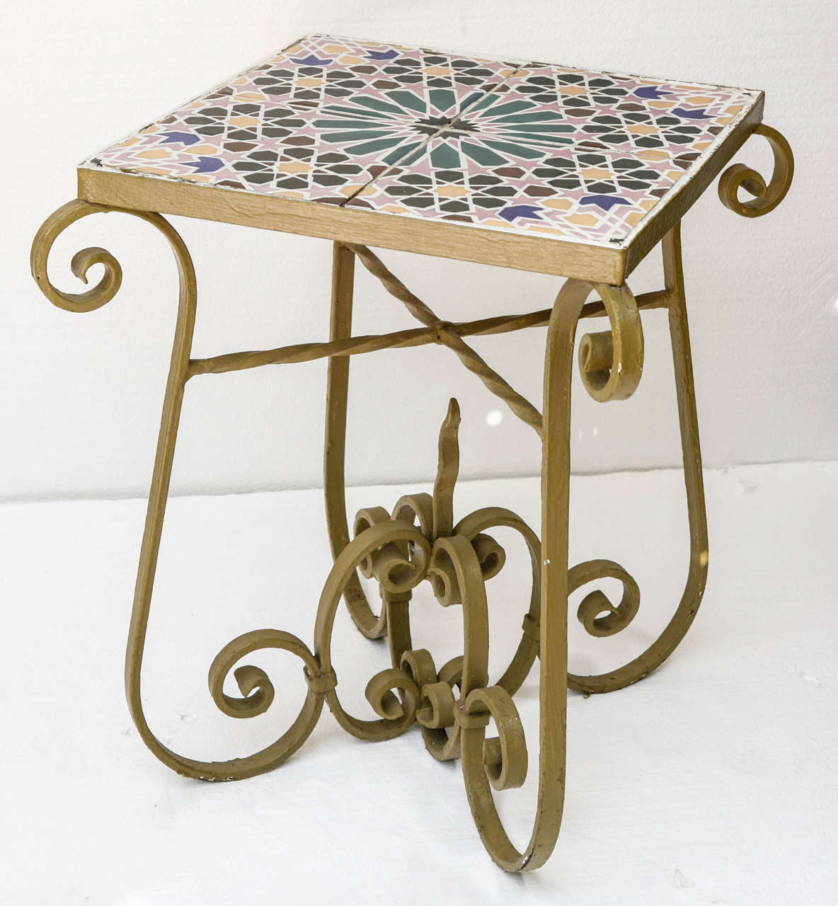 Pair of circa 1920 American tile topped tables with wrought iron bases.   Original four tiles compose the top surface. Old paint with many layers underneath.  Heavy and in great condition. 