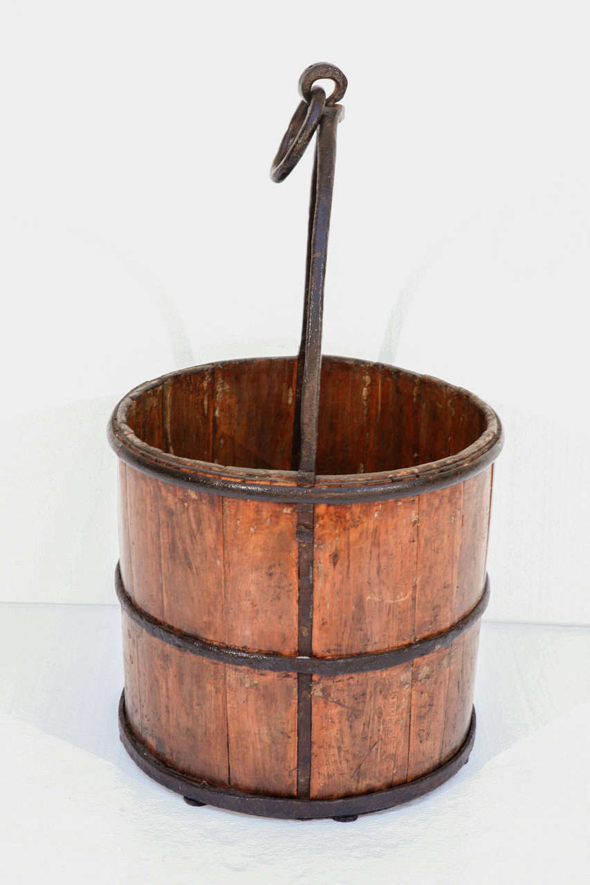 Antique water bucket in hardwood with iron straps and carrying frame.  Probably carried on a yoke. Great patina to both the iron and the wood. Two available.  