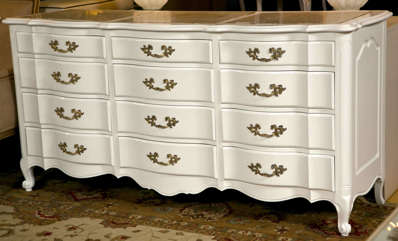 A white 12-drawer triple dresser with marble top. A finely constructed Louis XV style dresser in a white lacquered finish. The four by four by four commode curved drawer fronts supporting a group of three marble tops. The whole with fine heavy
