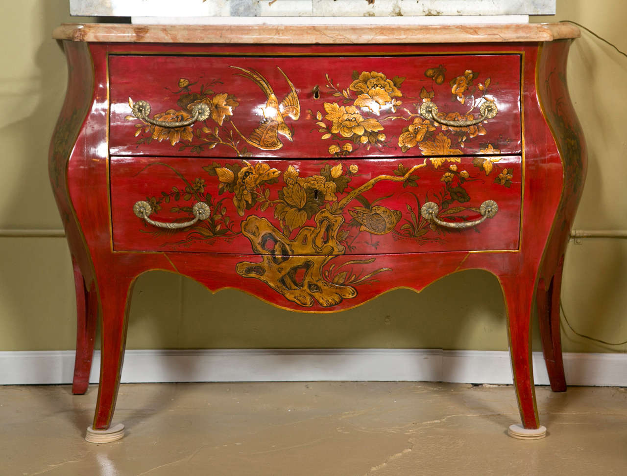 Fine and rare pair of turn of the century French chinoiserie style commodes, each having a beveled serpentine marble top, over a red-lacquered conforming case decorated with gilded chinosierie painted scene, supported on splayed legs. This Fine pair
