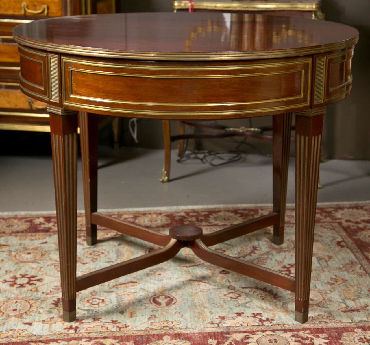 Fine flame mahogany Russian neoclassical centre table, circa 1860s. This table having bronze sabots leading to finely bronze fluted tapering legs supported by a bronze fluted undercarriage with pedestal center. The flame mahogany top wonderfully
