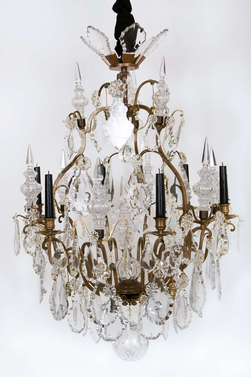A Louis XV style Bronze and Glass 6 light Chandelier.
An open cage frame issuing in total 12 arms with glass pendants in various designs and sizes and on 6 of them are placed ornaments 