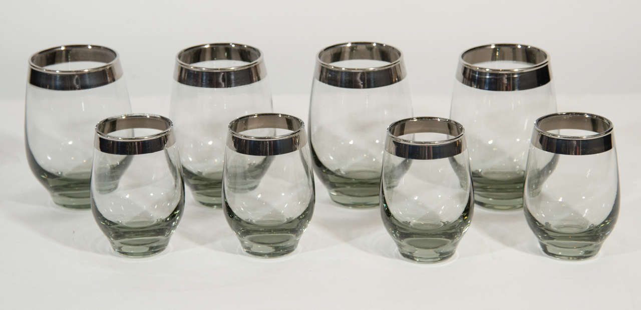Striking set of eight vintage barware glasses designed by Dorothy Thorpe. The set includes two different sizes of glassware (four wine/cocktail glasses, and four cordials/liqueurs/brandy). The glasses are comprised of smoked grey crystal glass with