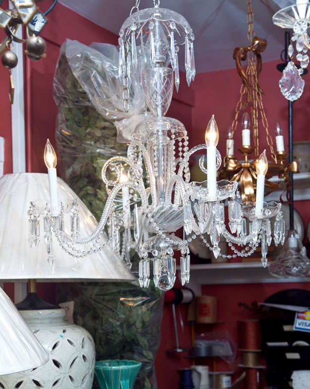 A glittering four-arm chandelier, all of Venetian glass and dripping with cut crystal.