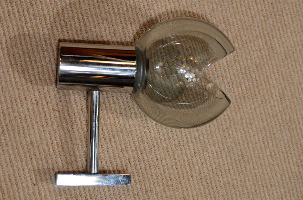 A lovely pair of grey glass globe and chrome sconces produced by Seguso in the 1960s. Each globe is handblown with a pie shape cut out on top and mounted onto a chrome arm. Documented in the Seguso catalog. Rewired. Sold as a pair.
Located in
