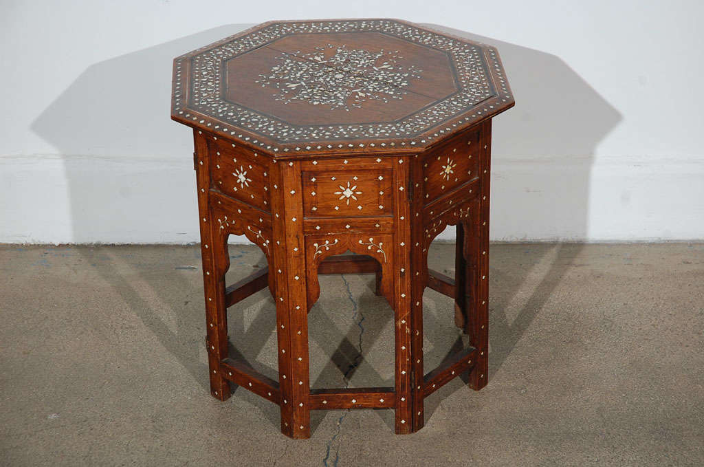 Fine and elegant Anglo-Indian octagonal rosewood table with elaborate bone and ebony inlay.The octagonal surface is finely carved and inlaid with bone and ebony designs of a large star and vines. The base fold flat.

Mosaik provides Antiques,Art