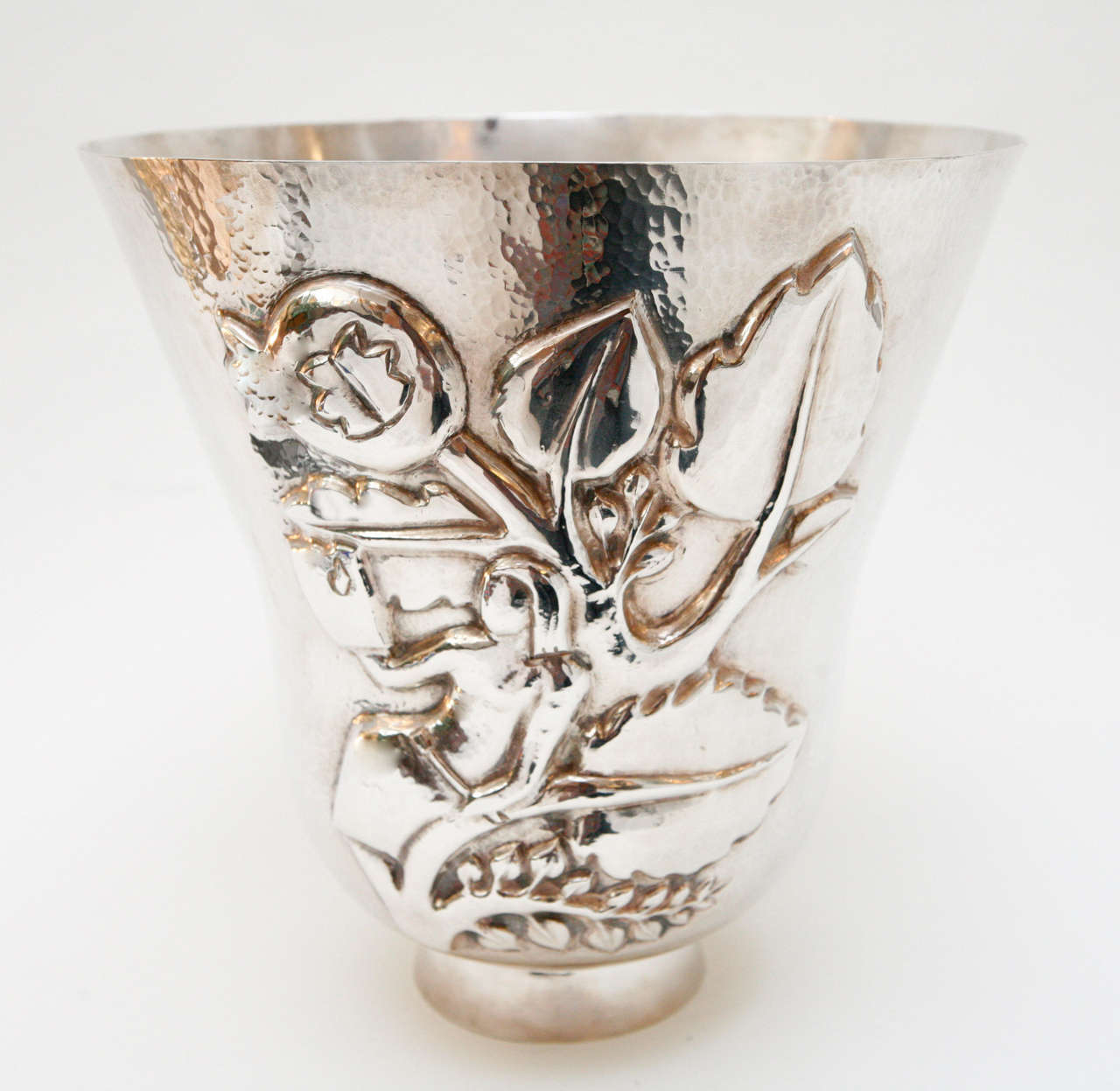 A striking, large silver plate Italian vase with hammered finish and a stylized botanical design and woman in relief on the front. Stamped at the side rim of the vase 
