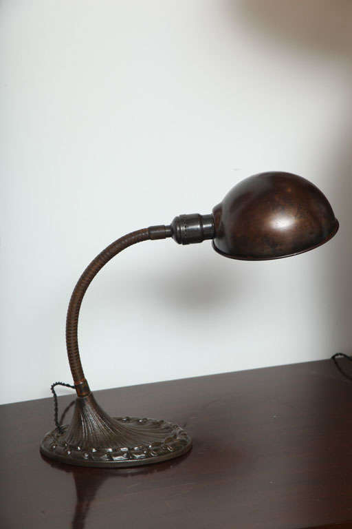 Antique industrial-style desk lamp made by the Aladdin Mfg. Company. USA, circa 1910. <br />
<br />
Features adjustable gooseneck with period-designed base and twist on-off switch. All original. Patinated brass (black) finish. <br />
<br