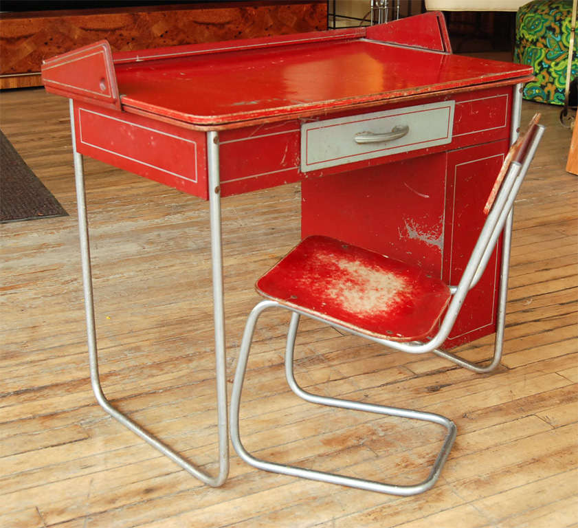 Childs desk and chair, with flip top chalk board surface. Tubular chromed steel with original fire engine red surface, and one drawer and two shelves. Pint sized Deco styling.