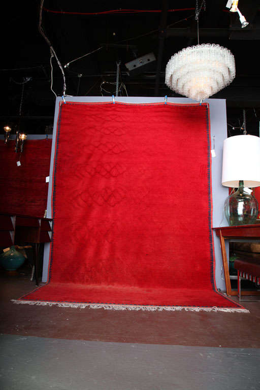 Wool carpet made by the Berbers in the Atlas Mountains in the 1950s. Red field with blue border. Excellent condition.