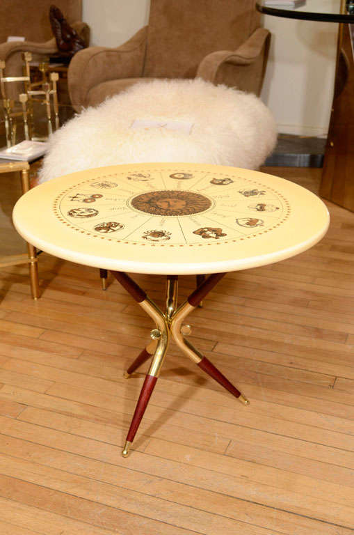 Round side table featuring zodiac design transfer printed top with wood and brass base by Piero Fornasetti.

View our complete collection at www.johnsalibello.com