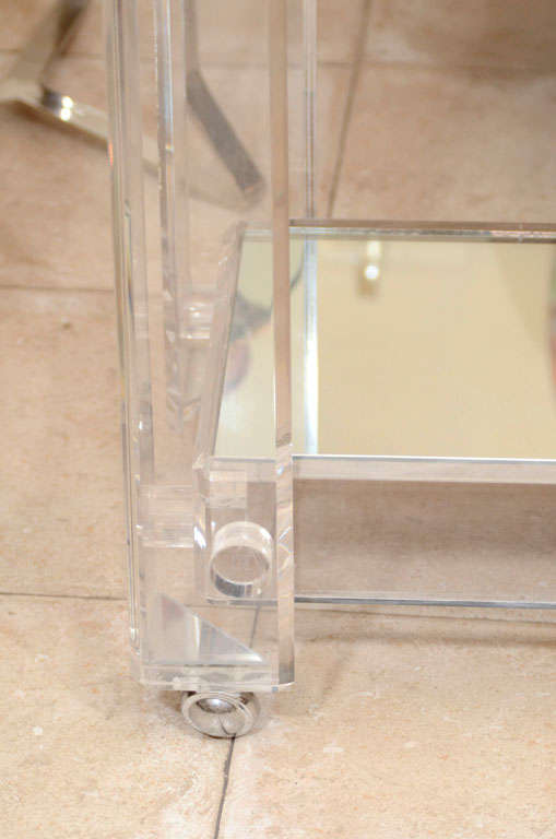 Late 20th Century Lucite rolling cart featuring two mirrored shelves
