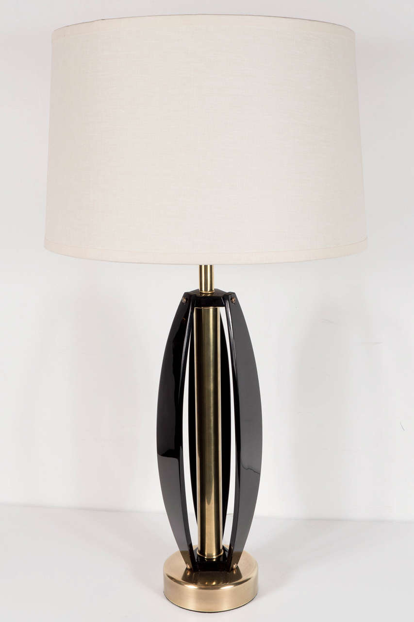 This chic pair of Mid-Century Modernist lamps consist of three banded panels of ebonized walnut which are convex in form out around a brass stem and are mounted to a brass circular base and have brass ball finials. They come with new custom shades