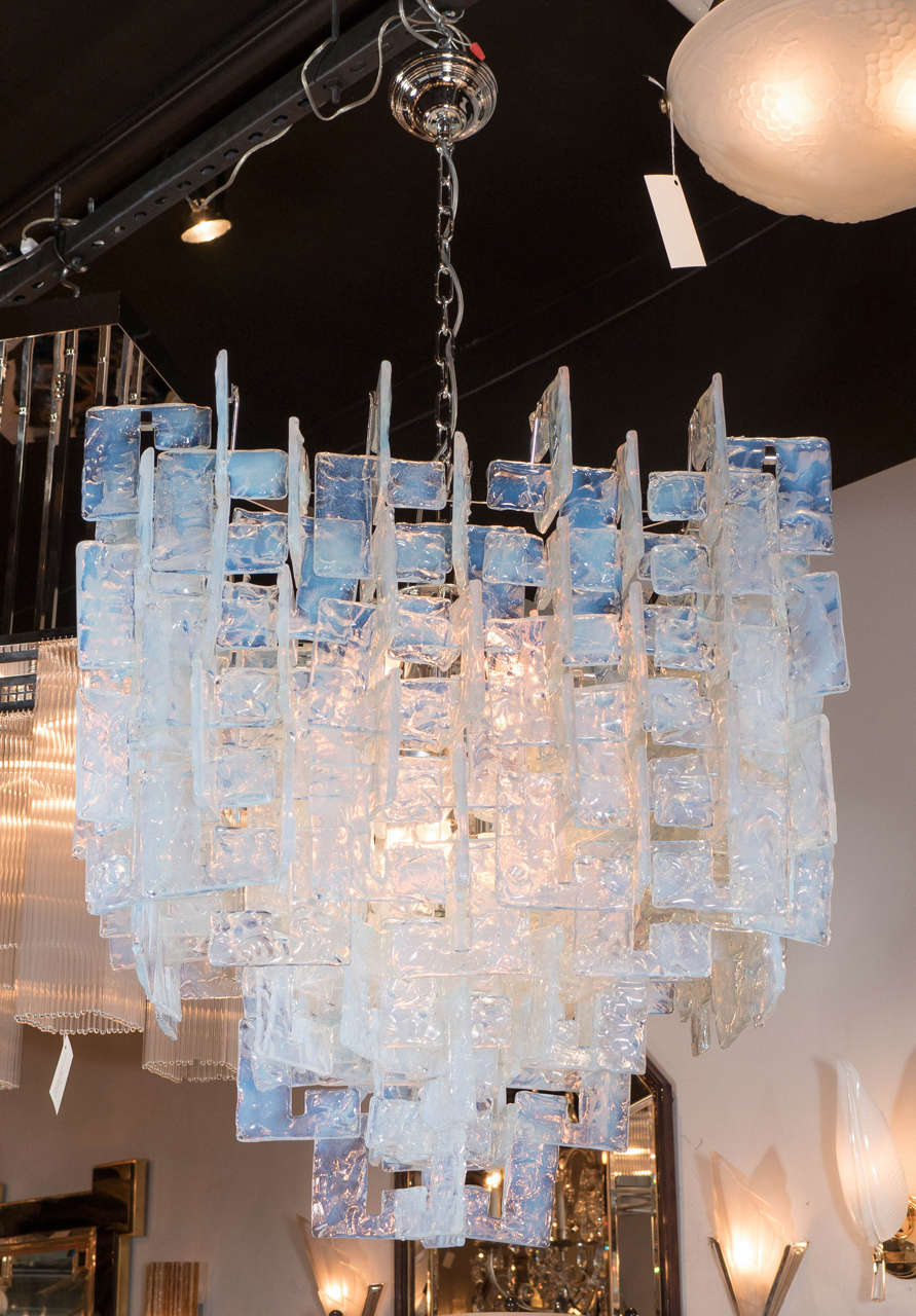 This exceptional Mid-Century Modernist chandelier was realized in Murano, Italy- the island off the coast of Venice renowned for its superlative glass production. It consists of numerous individual Murano glass 