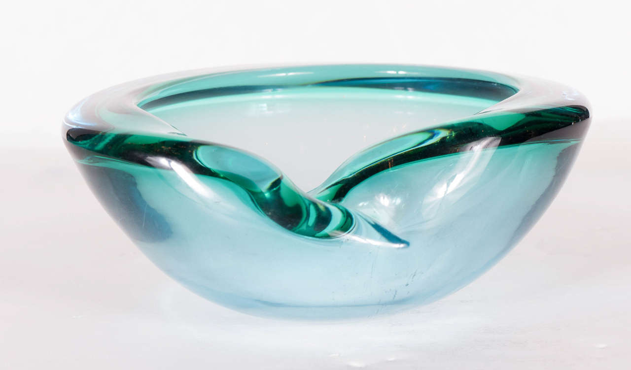 This stunning Mid-Century Modernist Murano bowl features an oval hand blown glass in Cerulean and Emerald with a slight overhang on the rim. It is in excellent condition.