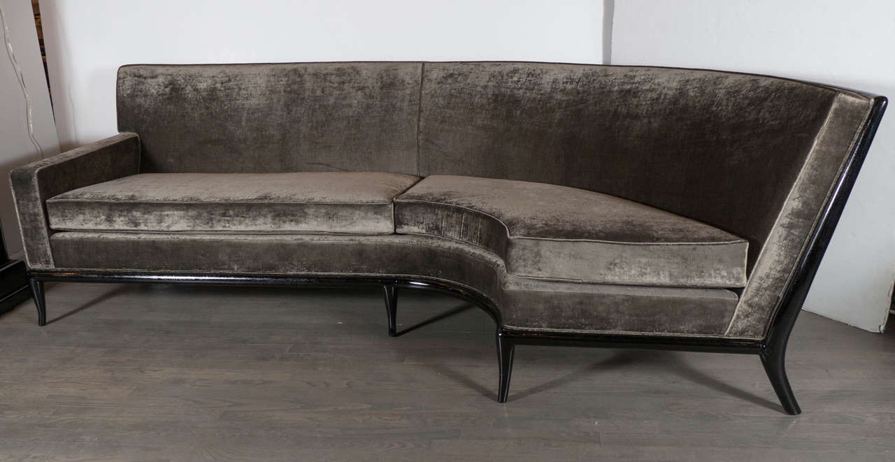 This luxe Mid-Century Modernist curved sofa by Robsjohn-Gibbings for Widdicomb features a fully upholstered seat and back in smoked pewter velvet with a low arm, the seat is supported by a sculpturally interesting base in ebonized walnut. This sofa