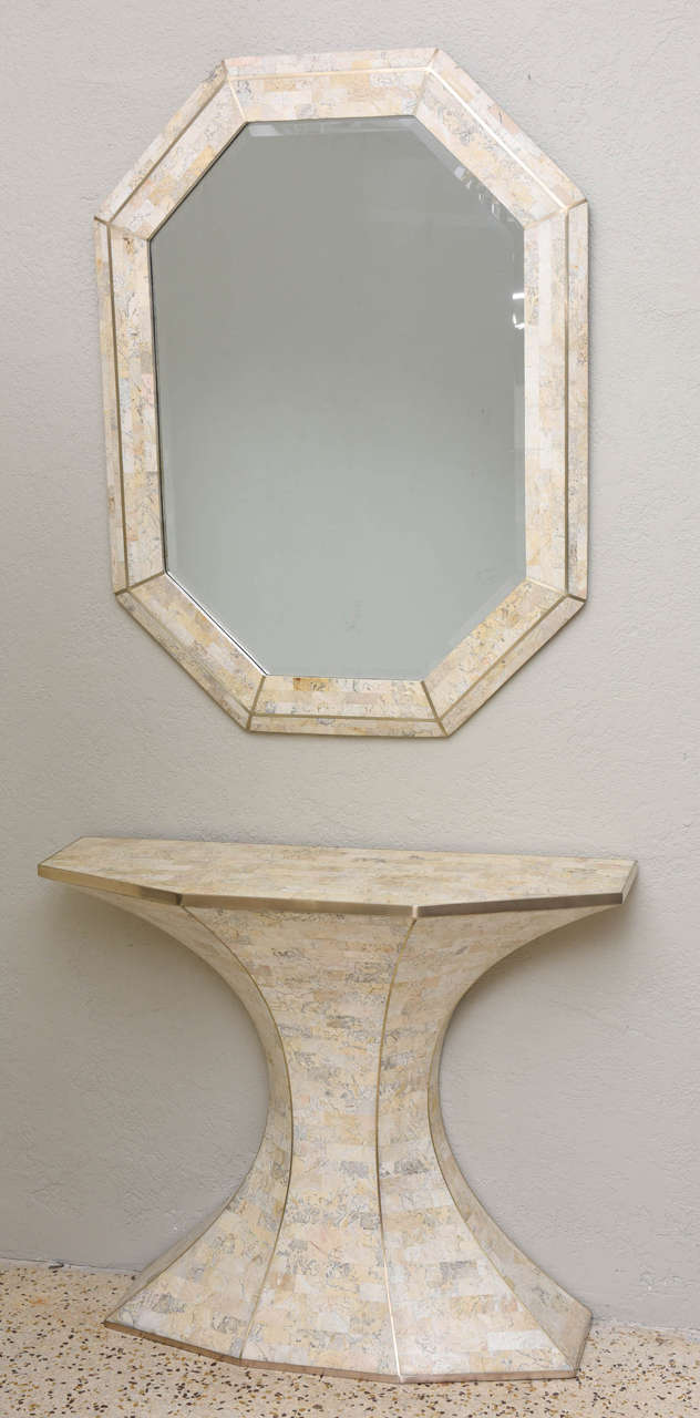 Tessellated marble mirror and console by Maitland-Smith. We love the Brasilia-inspired shape of the console and the gleaming brass inlays and trim. A rich and decadent visual moment! Mirror measures 40.5in. H x 30.5in. W x 1.25in. D. (Console