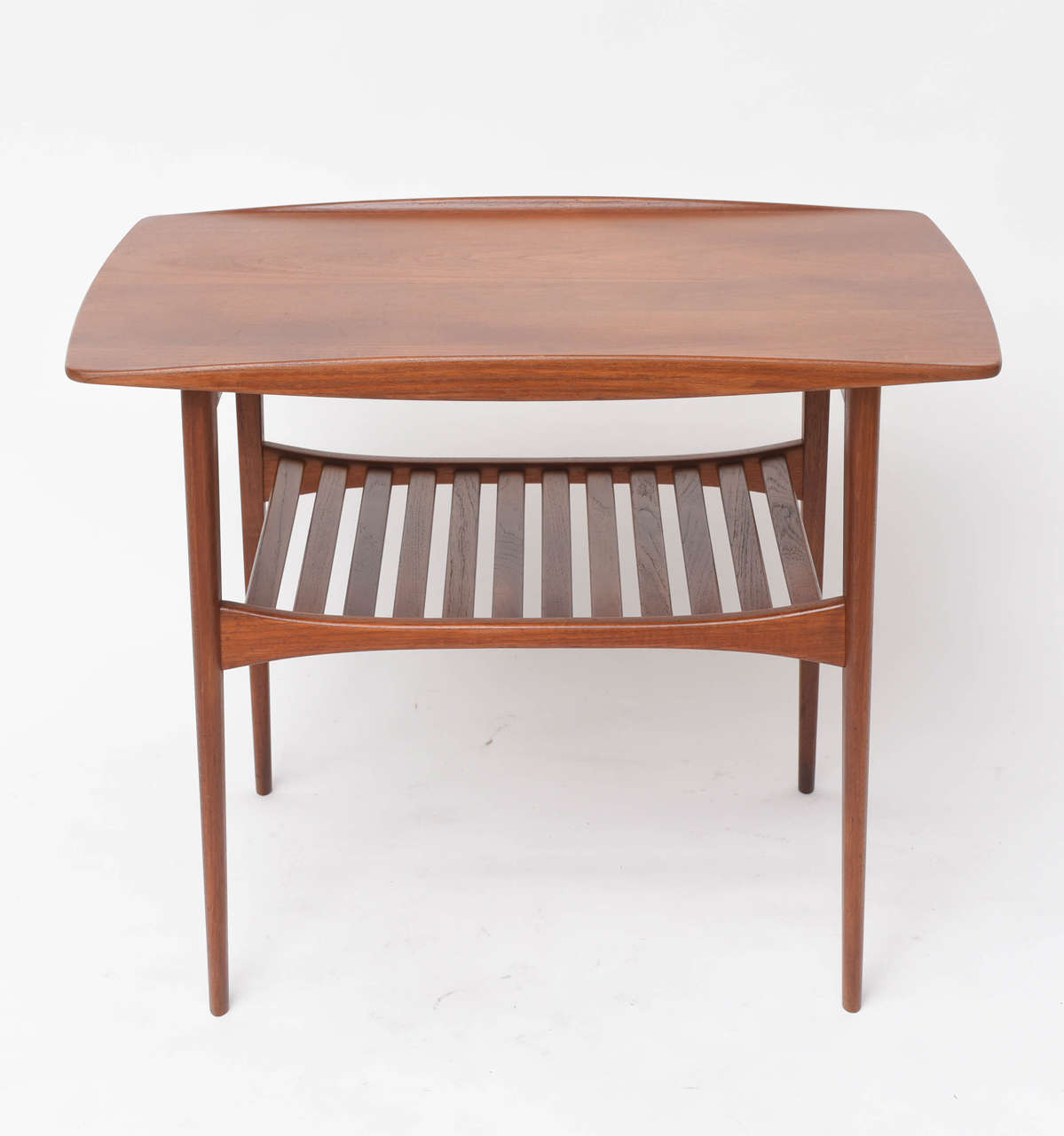 Pair of Danish modern end tables by Tove and Edward Kindt-Larsen for John Stuart. Solid teakwood with curved sides and slatted lower shelves.