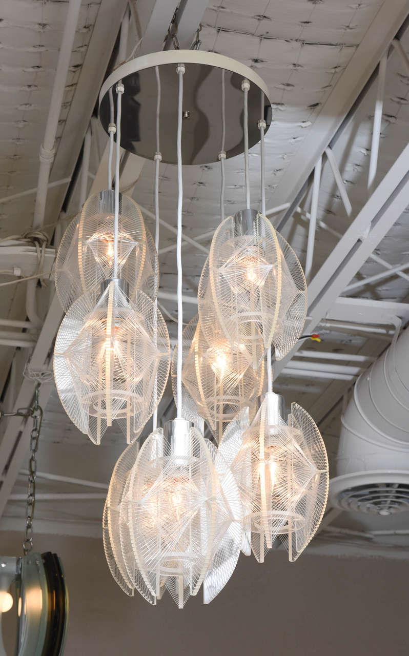 A wonderful feat of fun and fabulous… 1960s chandelier with monofilament-wrapped acrylic pendants suspended from a chrome canopy. So light, airy, and modern…with a touch of glamour.