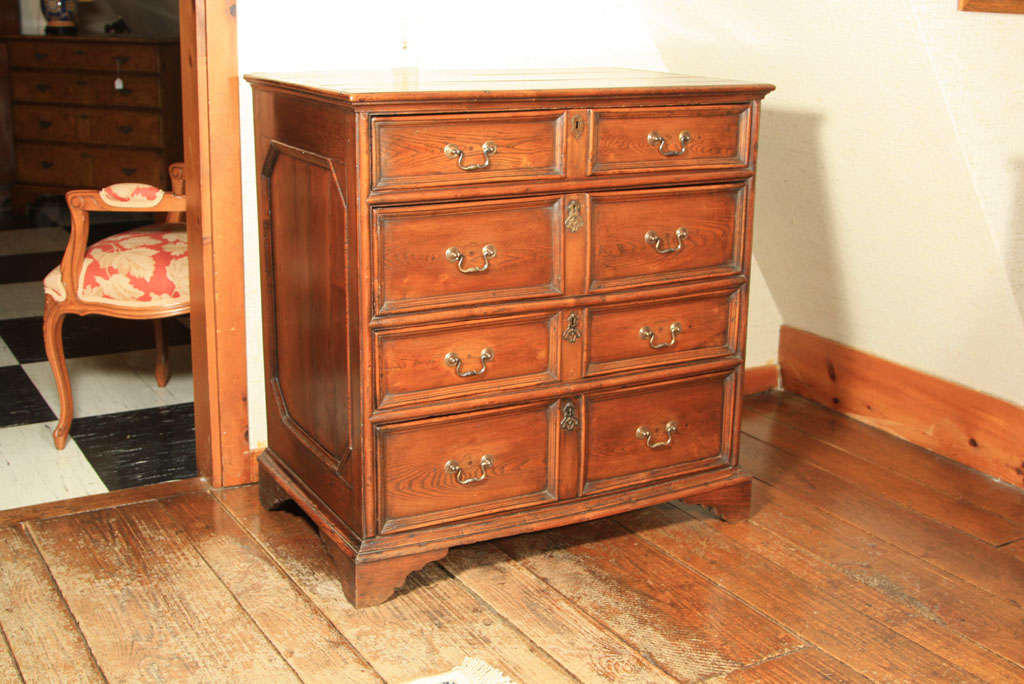 English oak four-drawer Jacobean style chest on bracket feet. Two shallow drawers and two deep drawers alternate down the case while and octagonal recessed panel on each side completes the authentic look of this 19th century re-imagining of a