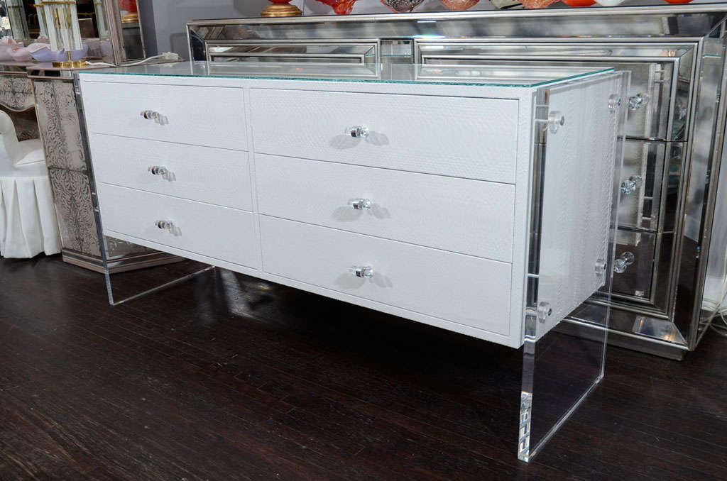 Comò a 6 cassetti in pitone bianco con pannelli laterali in lucite. La personalizzazione è disponibile in diverse dimensioni e colori.