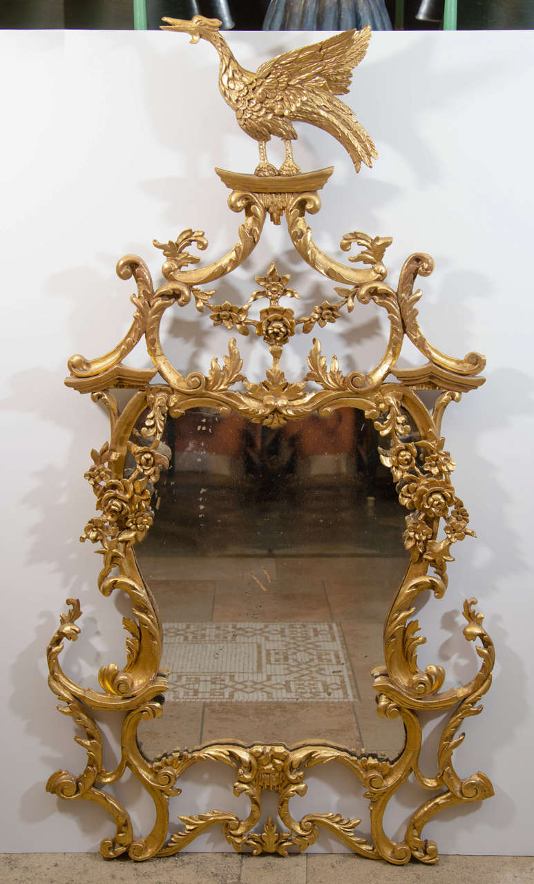 An unusual pair of carved giltwood Rococo phoenix crested console mirrors.