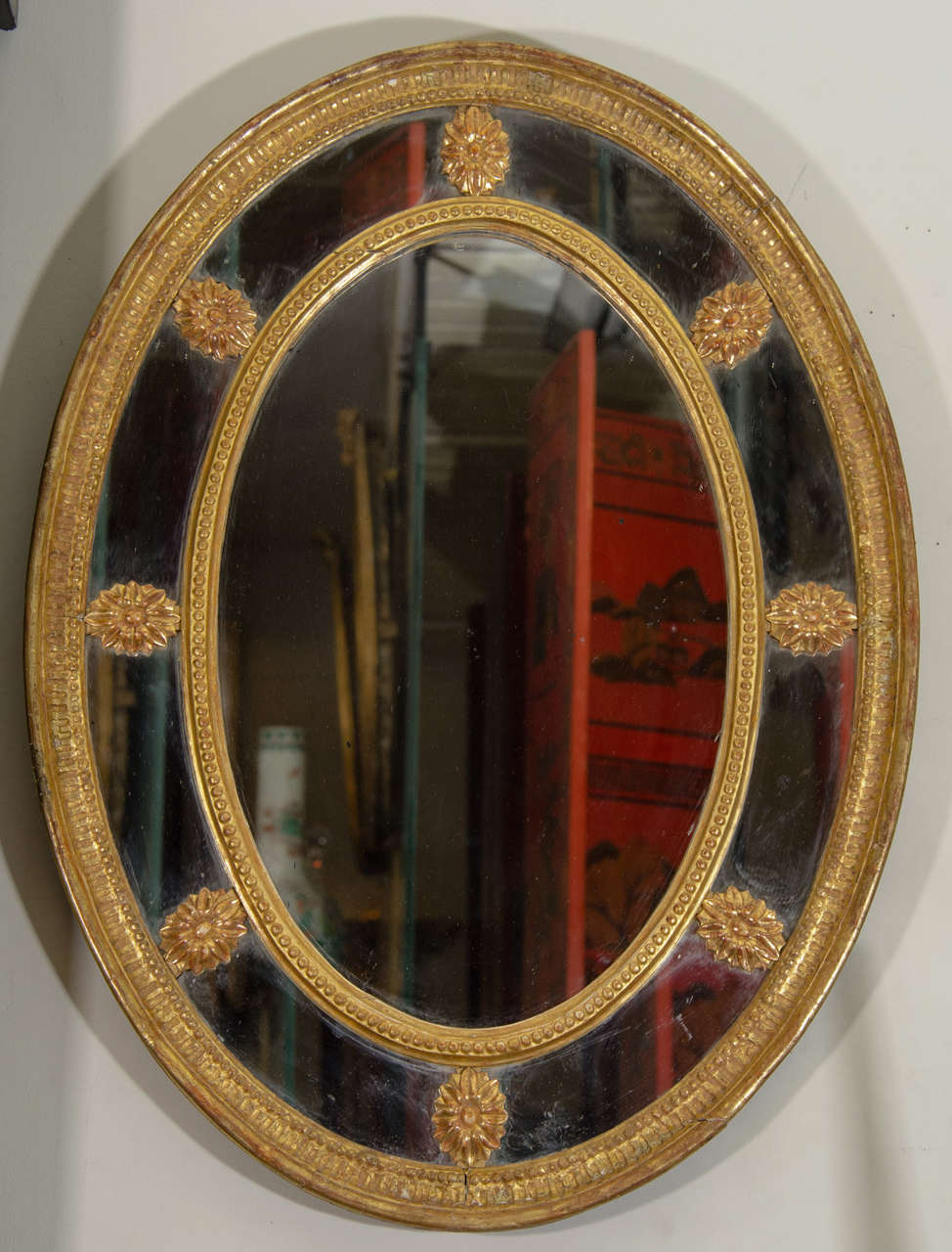 A George III oval border glass carved giltwood mirror.