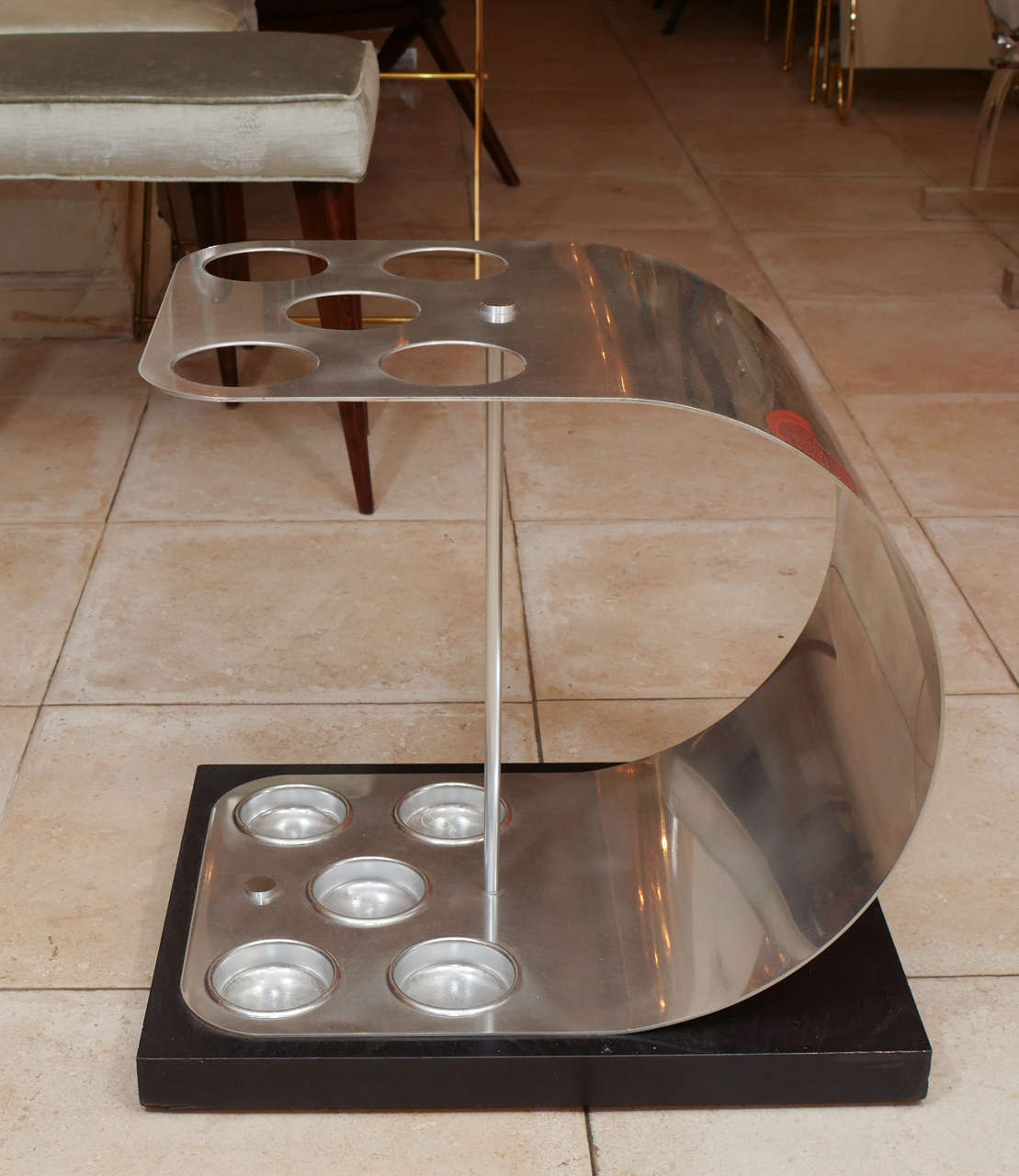Curved aluminum umbrella stand on a wood base.