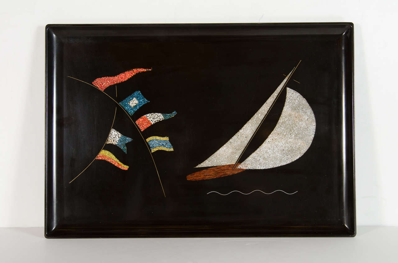 This inlaid black bakelite tray features a stylized ship and flag motif in nautical colors.