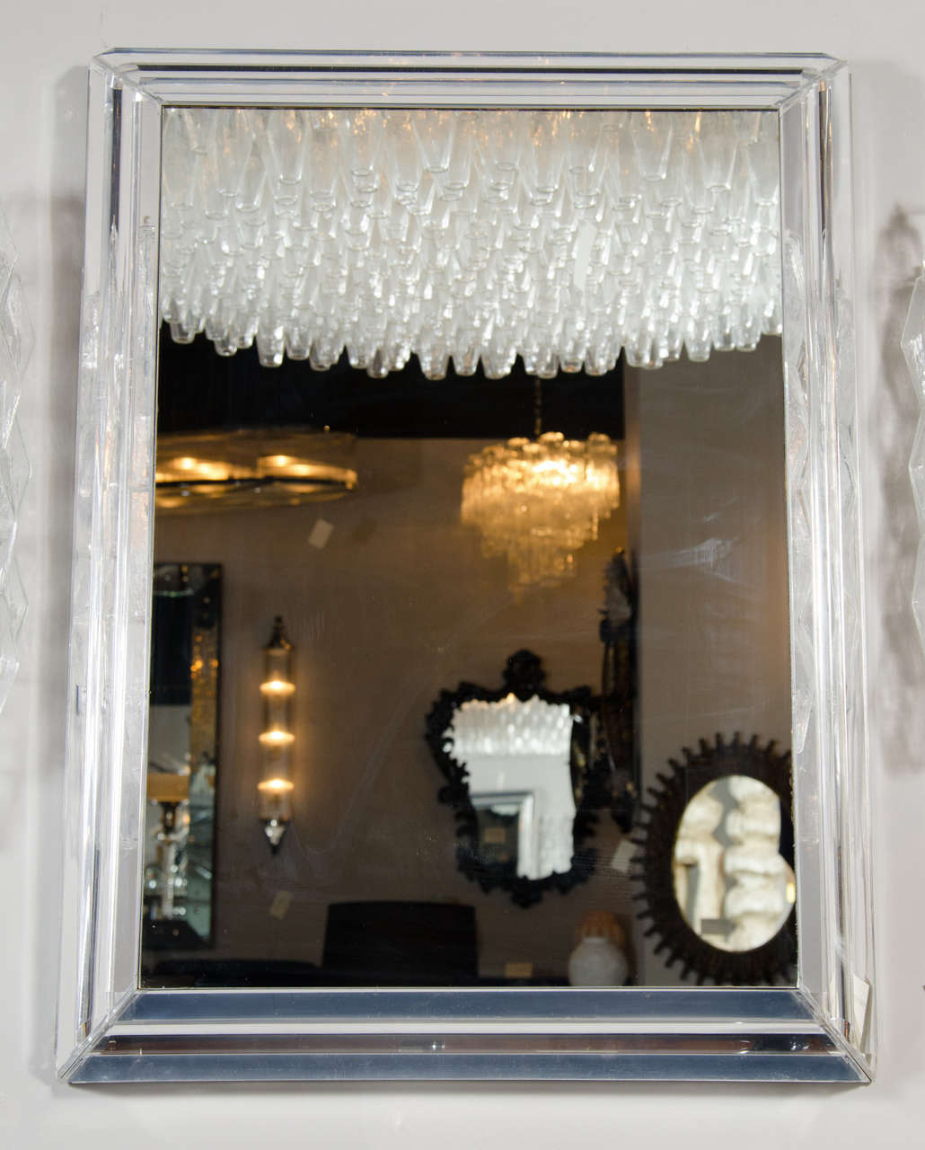 This Mid-Century Skyscraper style mirror is bordered in three rows of mirror-backed lucite rods in a stepped formation creating an interesting visual effect. It can be hung both horizontally and vertically.