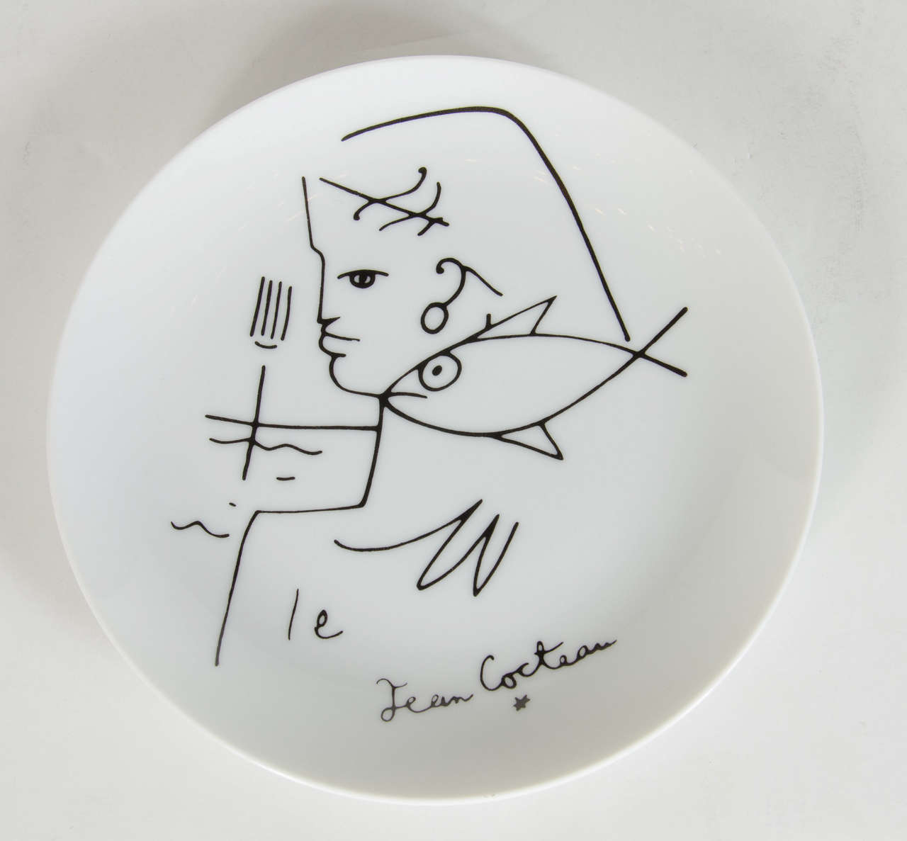 This plate features a stylized Neptune design by Jean Cocteau executed by the limoge company. A really great accessory for any room and it also can be hung on a wall or be on a plate stand as well. greta as wall decor or as an object in a bookcase