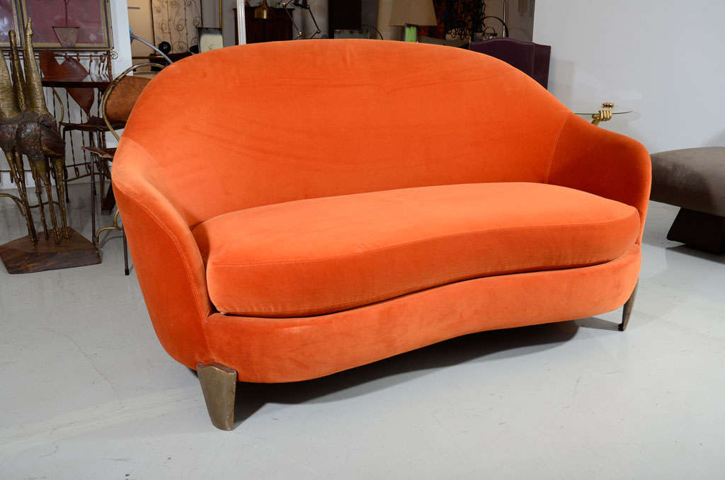 Beautiful orange velvet loveseat with graceful curves. The right front leg is signed on the inside with 