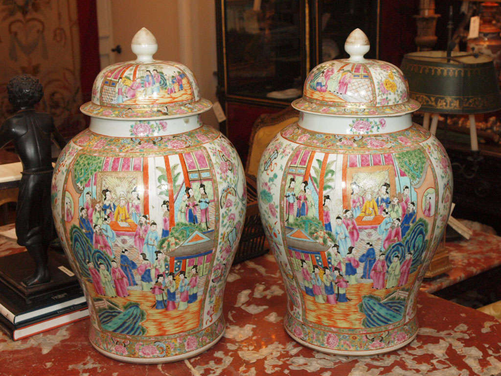 Pair of monumental palace sized Famille Rose Ginger Jars with lids with famillial scenes and rose and butterfly pattern borders.