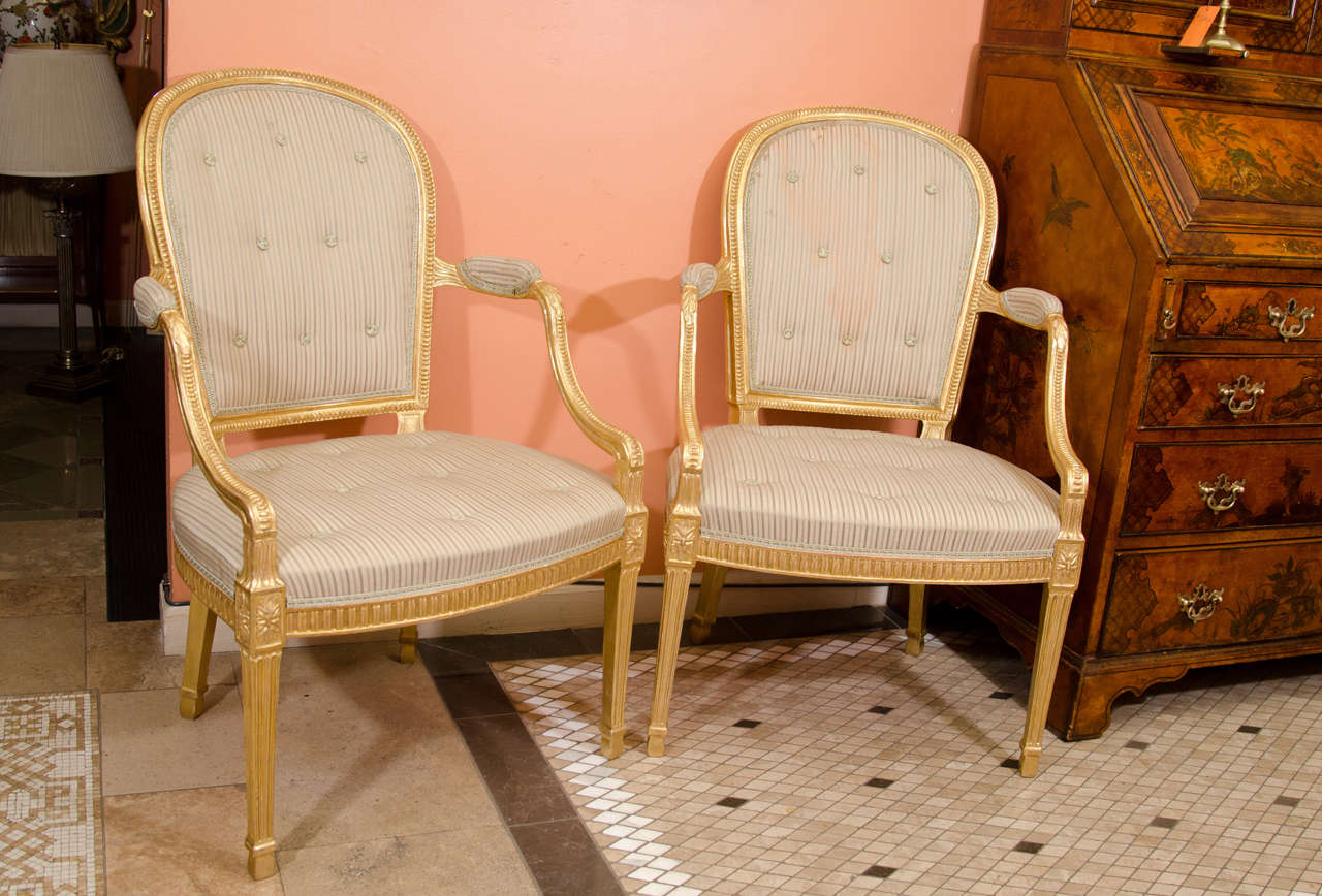 A Fine pair of George III carved gilt wood arm chairs with acanthus carvings and fluted apron and legs.