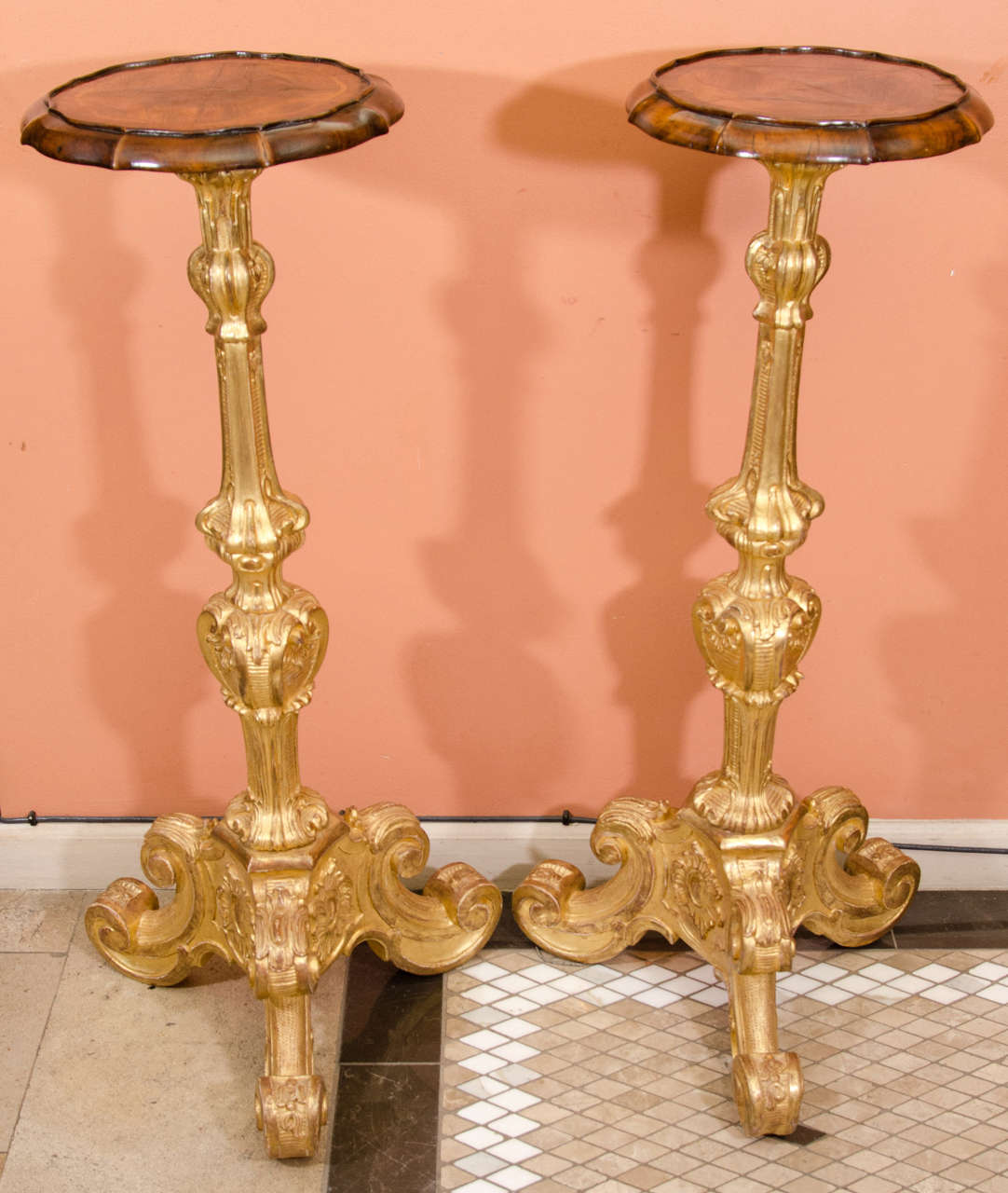 A fine pair of Baroque carved giltwood pedestals with inlaid walnut tops.