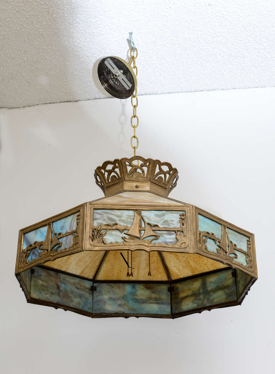American Arts & Crafts Chandelier with Slag Glass, nautical design with sailboats & seashore beautifully high lighted with blue slag glass on the sides & butter scotch on the upper section, restored original finish, newly rewired. There is one panel